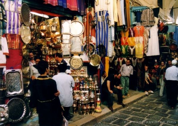 image-004 <p><b>Tunis</b></p>
<br>
<div align=left>
<p>Nach einer kurzen Verschnaufpause im Hotel haben wir uns auf den Weg in die Medina von Tunis gemacht, in die Souks. Hier werden in den schmalen Gassen Teppiche, Schmuck, Teller, honigtriefende Süßigkeiten und vieles mehr verkauft. Wir als Touristen sind natürlich das gefundene Fressen, und man kann kaum ein Auge auf die aufgebauten Waren werfen, ohne ein Gespräch am Bein zu haben. Robin hat uns durch einen Teppichladen auf die Dachterrasse geführt, von wo aus man einen herrlichen Blick über die Dächer von Tunis hatte.</p>
<p>Nach dem Abendessen gab's dann auch schon den ersten Thé Mente, ein Gebräu aus grünem Tee mit Pfefferminzblättern und vor allem viel Zucker.</p>
</div>