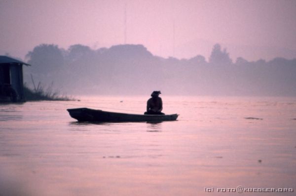 image-175 <p><b>Sonnenuntergang auf dem Mekong</b></p>
<br>
<div align=left>
<p>Den Sonnenuntergang wollen wir uns vom Boot aus anschauen. Gemächlich fährt uns der Bootsmann den Mekong rauf, dreht langsam beim Sonnenuntergang und schippert genauso langsam, aber diesmal mit quäkender Musik aus den kleinen Lautsprechern wieder zurück. Eine Stunde Fahrt war ausgemacht, und als wir nach einer Dreiviertelstunde auf den Anleger zusteuern, steht Cheffe dort und rudert mit den Armen, zeigt auf seine Uhr und rudert wieder.</p>

<p>Also noch eine Ehrenrunde... und wir legen zehn Minuten später erst an. Andere Mentalität.</p>

<p>Zum Essen sitzen wir wenig später gemeinsam im Restaurant unseres Hotels, scheinbar als einzige Gäste, und bekommen von Udo Cola und Rum ausgegeben, der heute Geburtstag hat. Reichlich beschwipst stolpern wir heute ins Bett.</p>
</div>