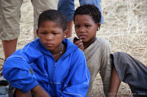 IMG_3427 <p><b>Bushmenwalk</b></p>

<P>Die San-Familie hat vier Kinder dabei, die aber nicht wie ihre Eltern die traditionelle Lederkleidung tragen, sondern T-Shirts. Die größte der vier geht bereits zur Schule.</P>