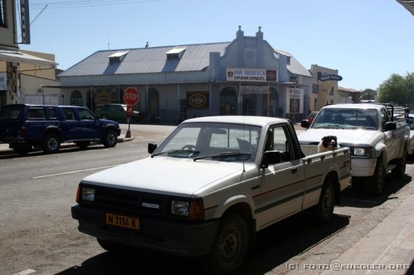 IMG_3491 <P><B>Keetmanshoop</B></P>

<div align=left>
<P><B>20. Oktober: Keetmanshoop, Köcherbaumwald, Giants
Playground und Fish River Canyon.</B></P>

<P>Noch vor Sonnenaufgang, etwa um 5.00 Uhr rührt sich wieder
etwas in unserem Camp. Um 5.30 Uhr ist schließlich auch
offiziell Aufstehen befohlen, denn um 6.00 Uhr sollen wir fertig
gepackt und Zelte abgebaut am Truck zum Frühstücken sein.
Mit kurzer Katzenwäsche wird die Zeit schon etwas knapp... aber
für den ersten Morgen ist Konrad mit uns zufrieden.</P>

<P>Zum Frühstück gibt es Kaffee und Tee, Toast, Marmelade
und Erdnussbutter. Über Nacht ist es doch merklich abgekühlt,
der Wind ist recht frisch. Unser Weg führt uns erst einmal
wieder auf schnurgerader Straße Richtung Süden, bis wir
nach 230 km Keetmanshoop erreichen, die Hauptstadt des Südens.</P>
</div>