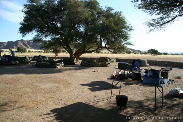 IMG_3619 <P><B>Sesriem Camp</B></P>

<div align=left>
<P>Am Camp angekommen stellen wir inzwischen zum dritten Mal die Zelte auf. Wir sind unmittelbar an der Namib, es sind 42°C im Schatten - und wenn man diesen verlässt, fühlt es sich an, als würde man zu nah am Grill stehen. Leider fegt ein immer kräftiger werdender Sandsturm immer wieder Sand in die Zelte und wir geben die Versuche das Zelt auszufegen, auf. Nachdem ein paar Zelte sogar vom Sturm umgekippt wurden, lösen wir die Klammern vom Gestänge und lassen die Zelte in sich zusammenfallen. Mit den Taschen und Rucksäcken darin sind sie nun schwer genug und
es sollte nichts weiter passieren.</P>
</div>