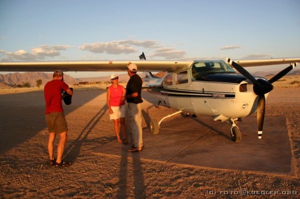 IMG_3905 <P><B>Gelandet</B></P>

<div align=left>
<P>Trotz kräftigem Seitenwind setzt unser Pilot ganz sanft wieder auf der Landepiste auf und wir schälen uns aus unserer Büchse heraus. Es hat mehr Spaß gemacht, als wir uns haben träumen lassen, und eine solche Landschaft von oben sehen zu dürfen ist einfach einmalig.</P>

<P>Zum Abendessen gibt es heute gegrilltes Fleisch, Burenwürstchen mit Kartoffeln, Möhren und Kürbis - mal wieder sehr gut. An der Bar trinken wir mit einigen Anderen noch ein paar Bierchen und kriechen frisch geduscht in den Schlafsack.</P>
</div>