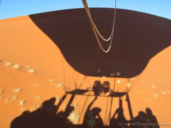 IMG_6634 <P><B>Ballonfahrt</B></P>
<div align=left>
<P>Die Stunde geht viel zu schnell vorbei. Während der erste
Ballon bereits vor den Dünen im Steppengras landet, schleppen
wir uns gerade noch über eine Düne und bleiben schließlich
an der letzten kleben. Der Auftrieb der heißen Luft reicht
schon nicht mehr aus, da die Sonne die umgebende Luft so schnell
aufheizt.</P>
</div>